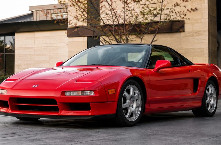 A red Acura NSX outside a modern building